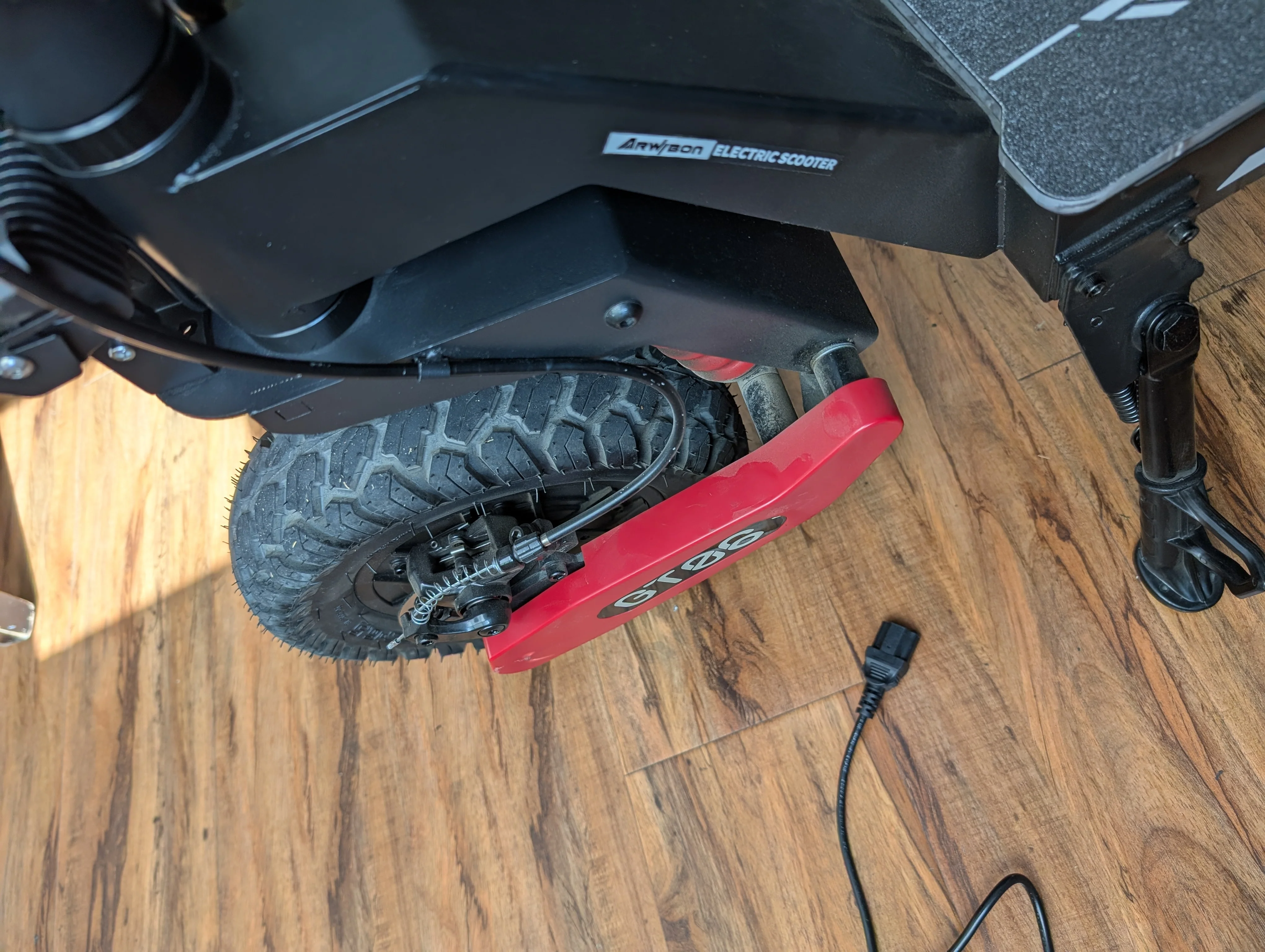 Pair of orange protective covers for the front wheel of the GT06Plus scooter.